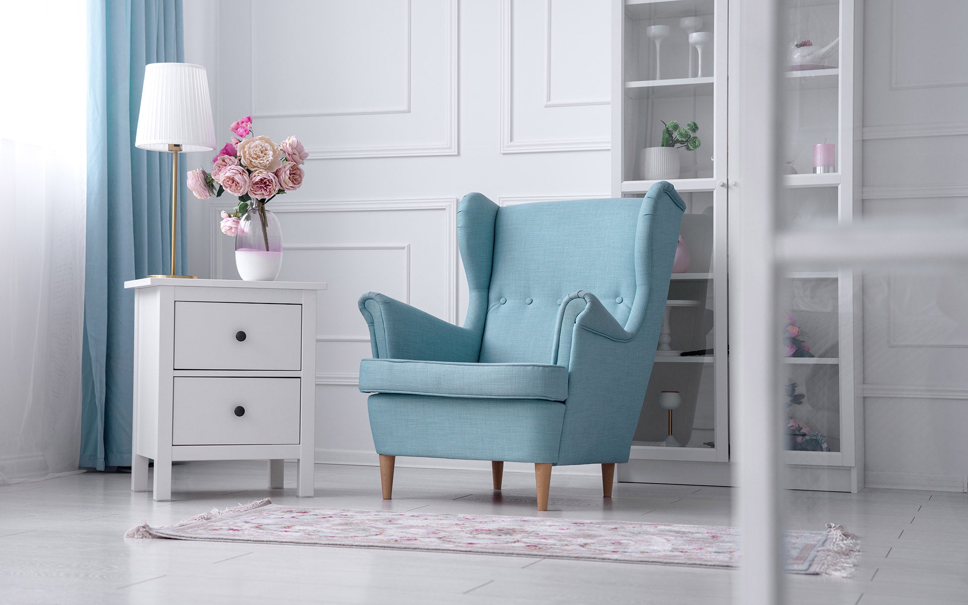 Green accent chair in bedroom with small bedside table