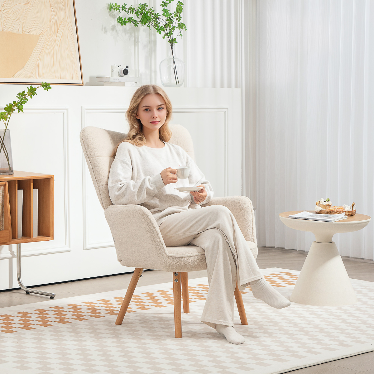 Woman relaxing in a cream tufted wingback armchair with fleece upholstery in a bright living room.