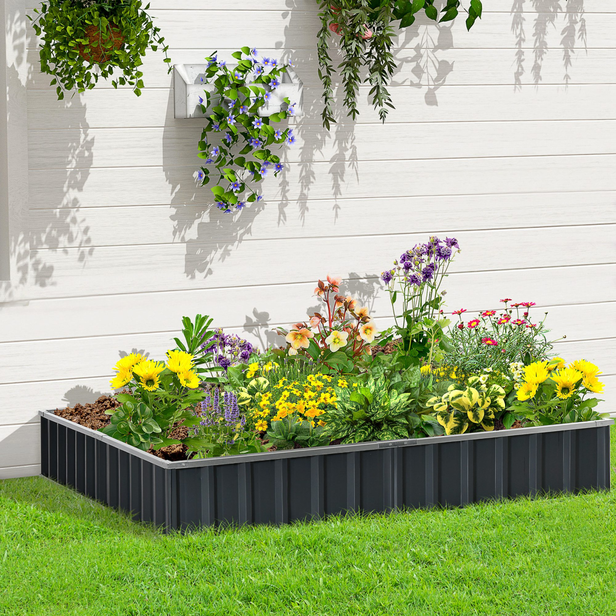 Outsunny metal raised garden bed 258x90cm with gloves kit, filled with colorful flowers along a white wooden fence.