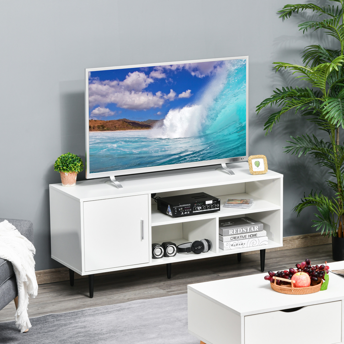 HOMCOM 120cm white TV stand with cable hole, three open storage cubes and a cabinet, TV on top.