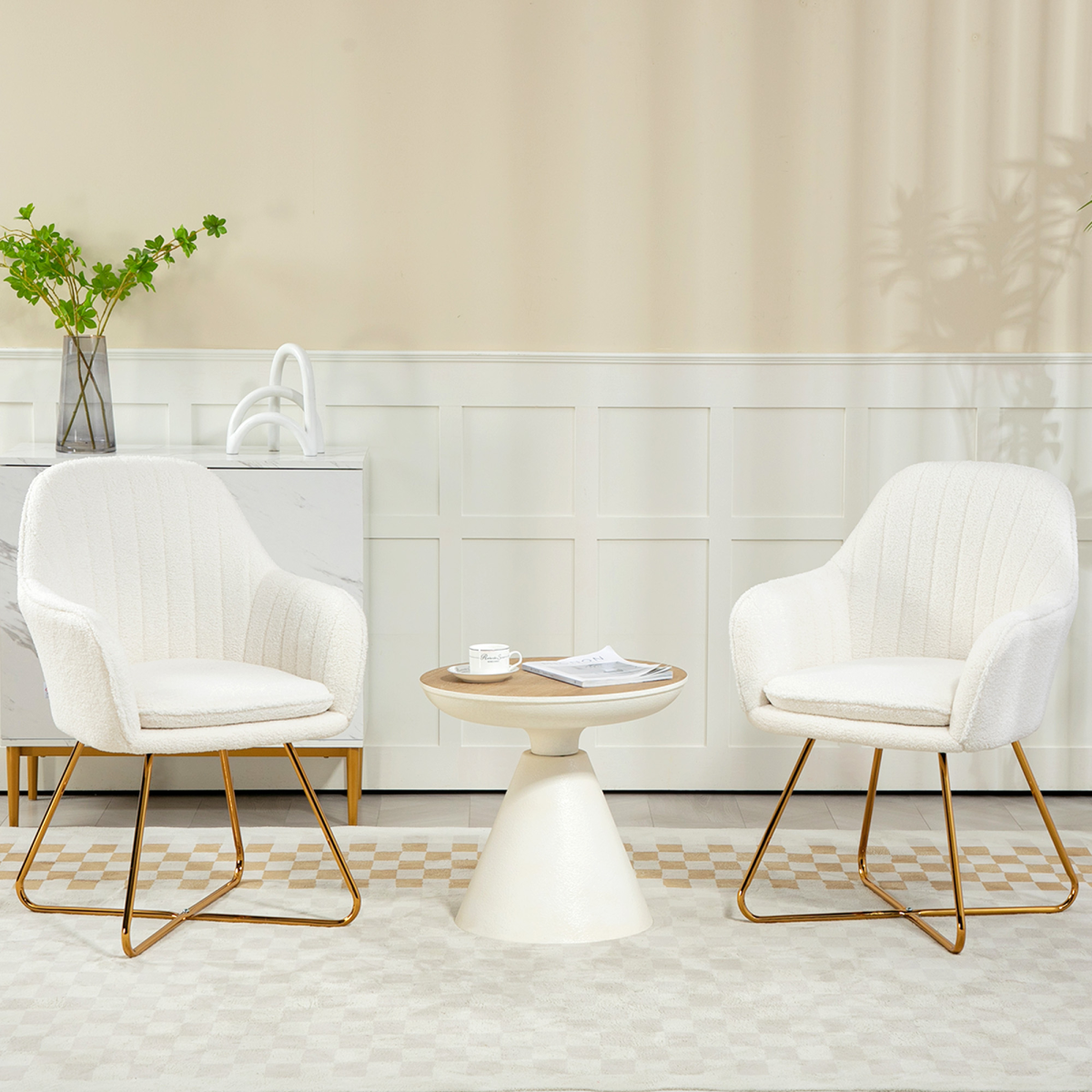 Two compact cream cashmere lounge chairs with gold legs in a bright, minimal living room.