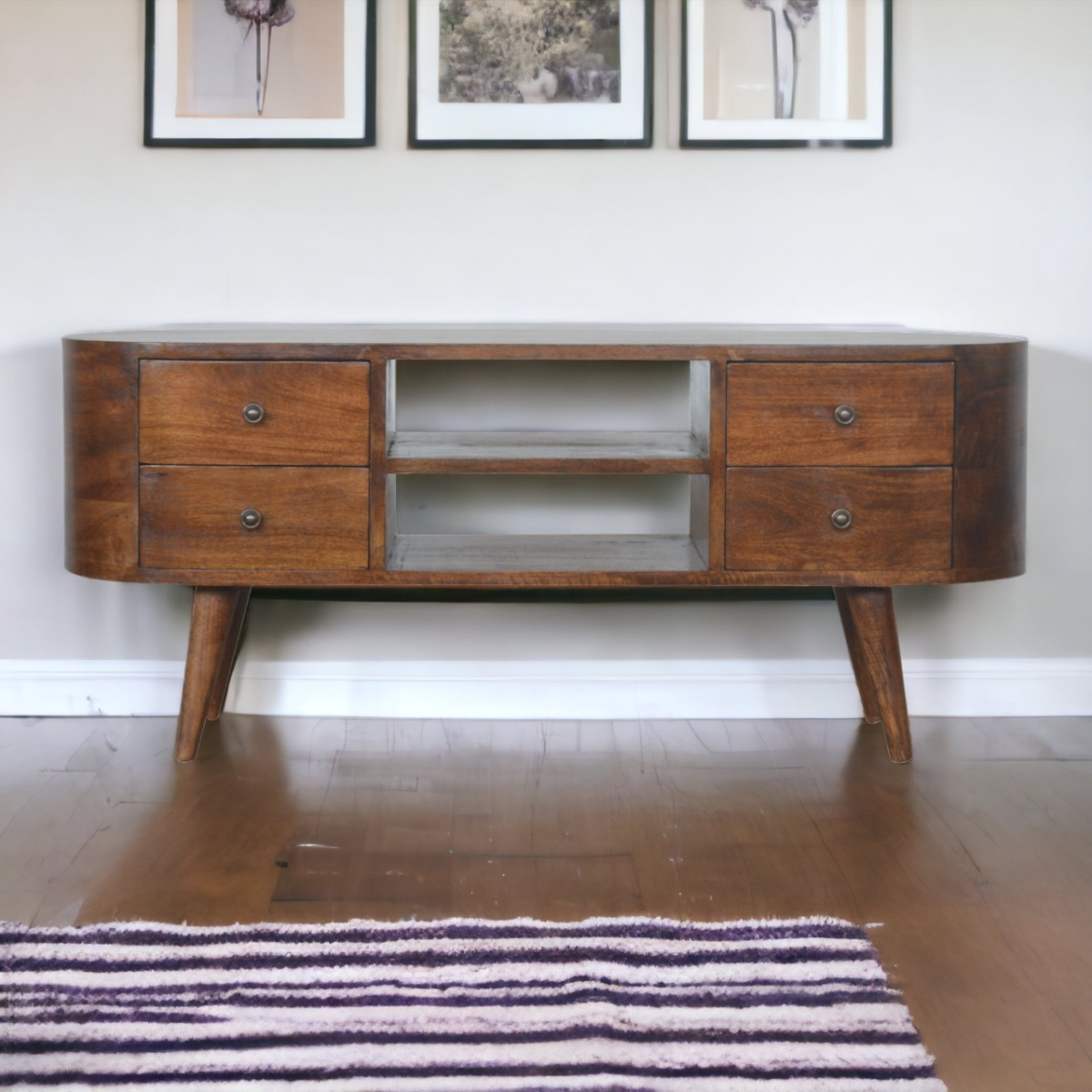 Artisan Entertainment Unit in chestnut solid mango wood with rounded edges, four drawers and shelves on tapered legs.