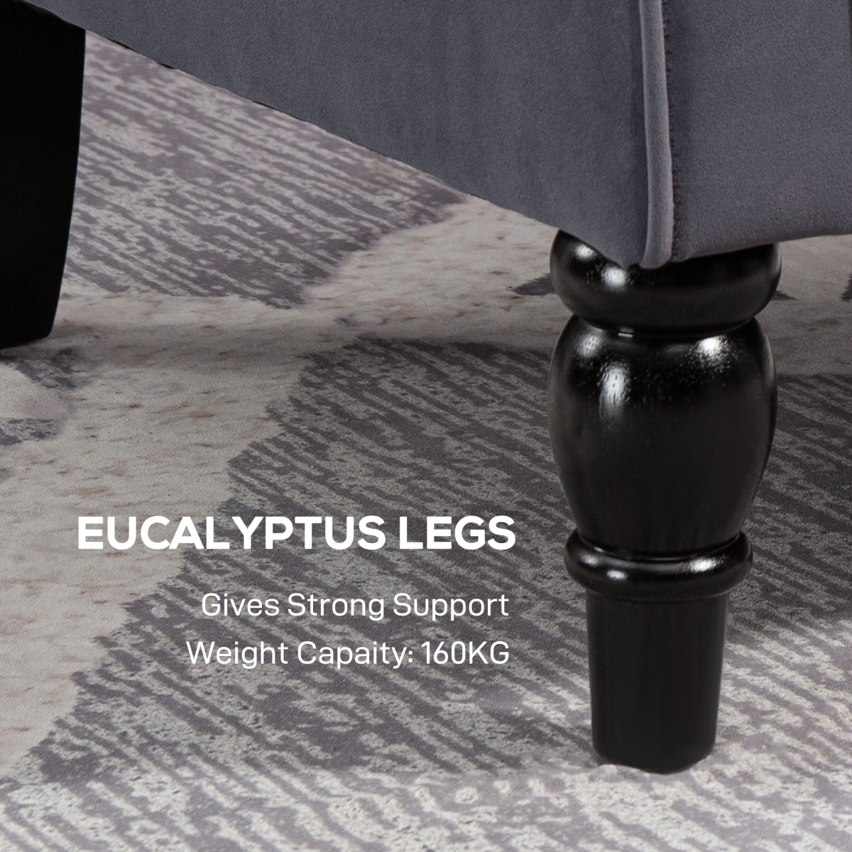 Close-up of a dark eucalyptus leg on a charcoal velvet accent armchair.