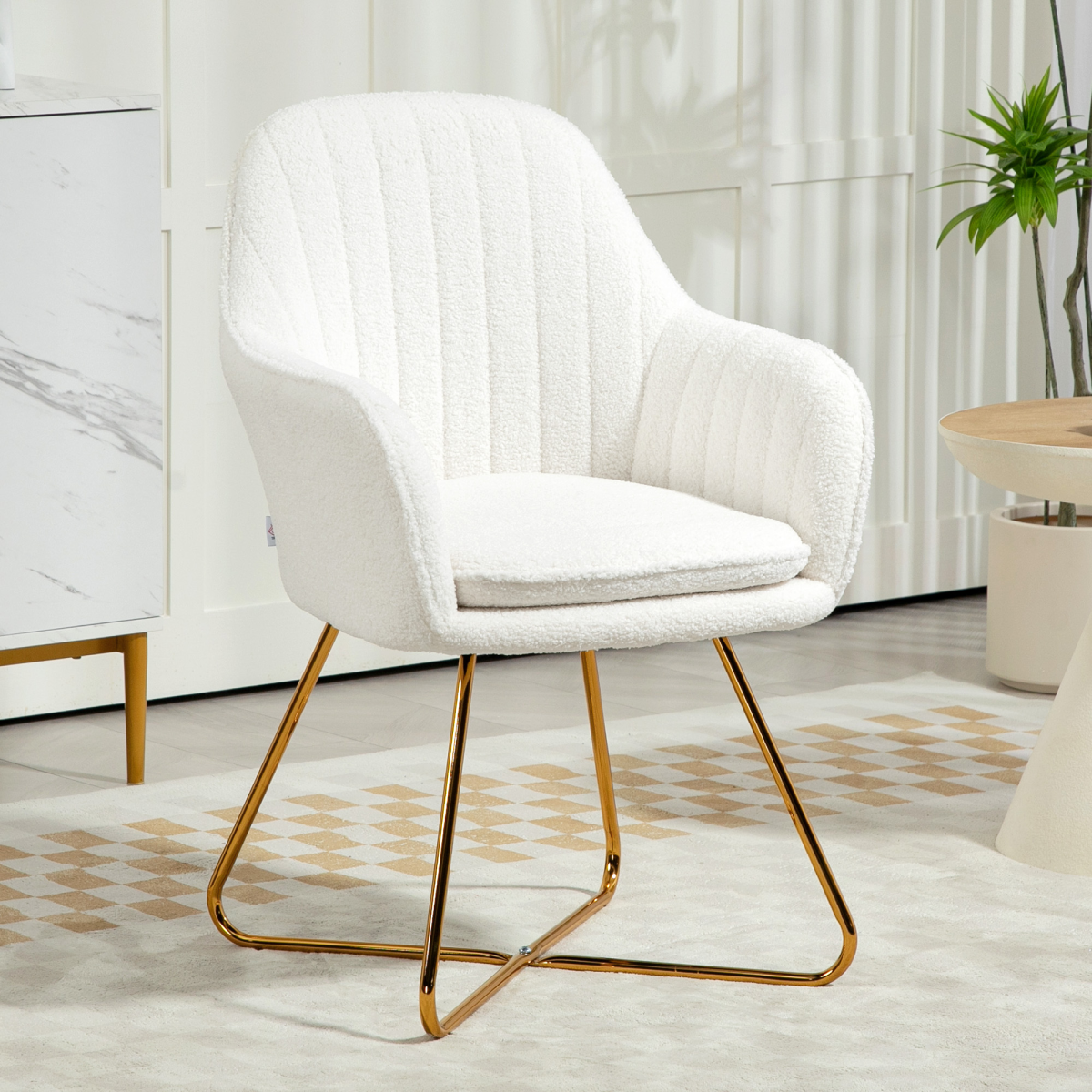 Cream cashmere upholstered accent chair with gold legs in a modern living space.