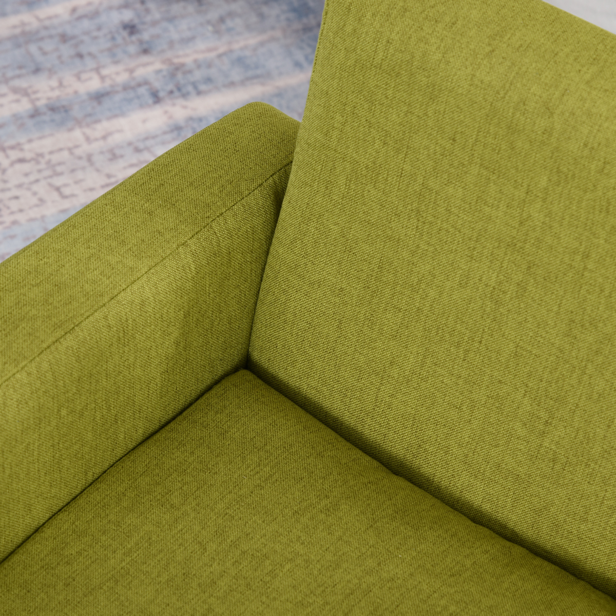 Green padded child armchair with wood frame; close-up of upholstery.