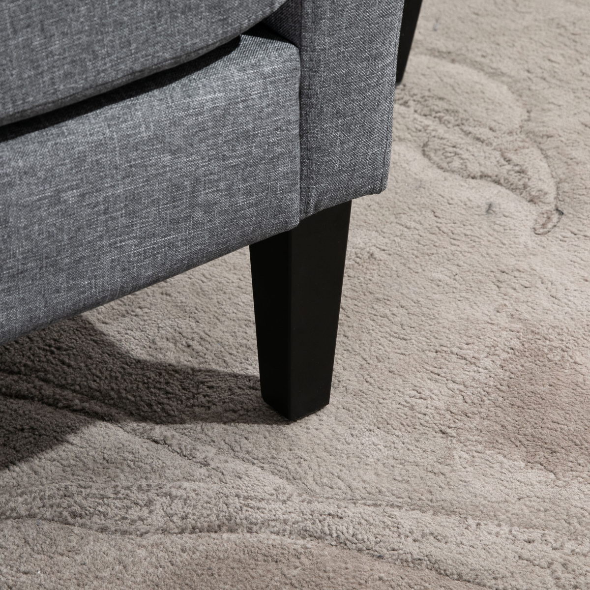 Premium linen armchair with curved arms in grey, black wooden leg on beige rug