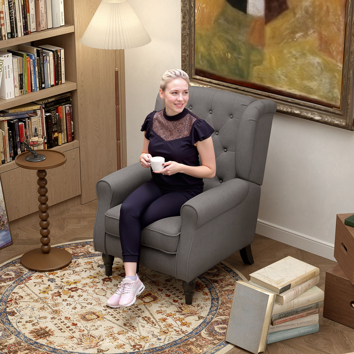 Accent Armchair in grey fabric with tufted wingback, shown in a cozy lounge with bookshelves and rug.