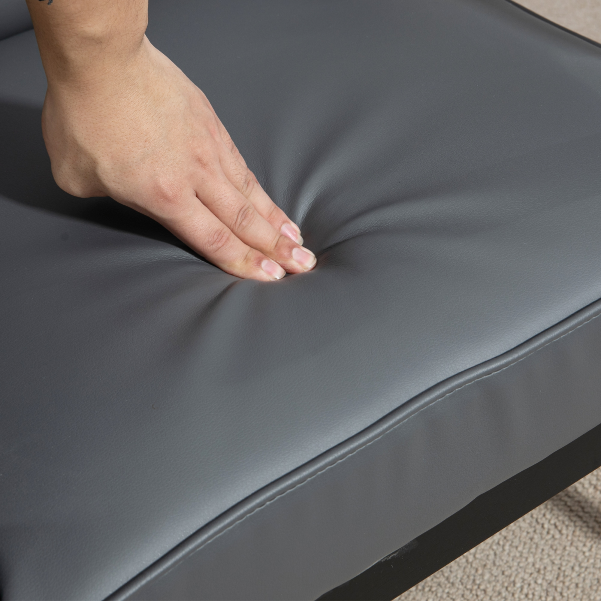 HOMCOM Accent Chair PU Leather Tufted Grey for Living Room hand pressing the grey faux leather cushion, tufted back