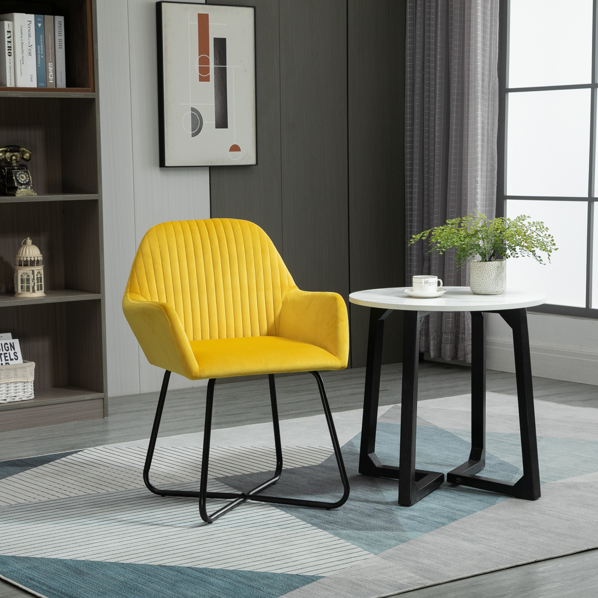 Compact yellow velvet accent chair with vertical tufting and black legs beside a round white table.