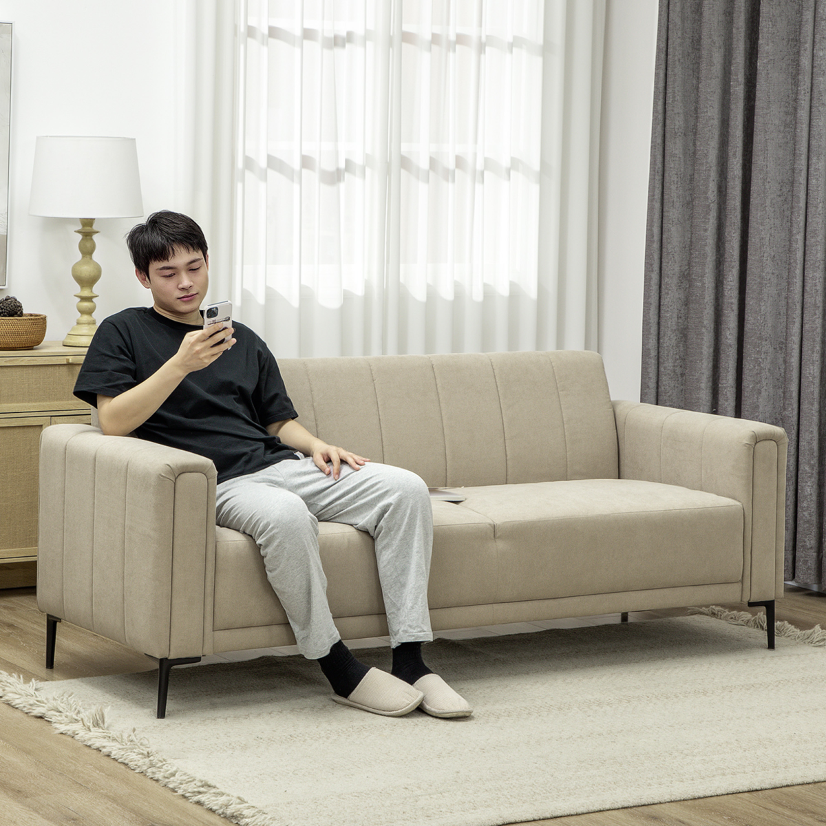 HOMCOM Three Seater Sofa Full Size Channel Tufted For Home beige fabric with a person seated in a modern living room.