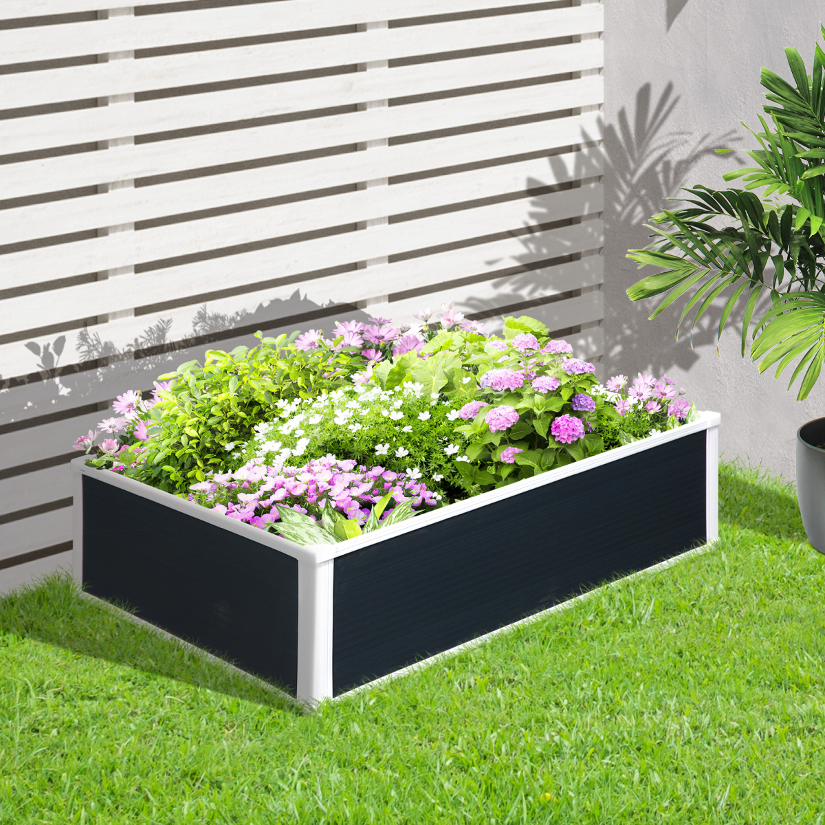 Outsunny garden raised bed planter 40x14x8 with white frame and black panels, filled with pink and white flowers