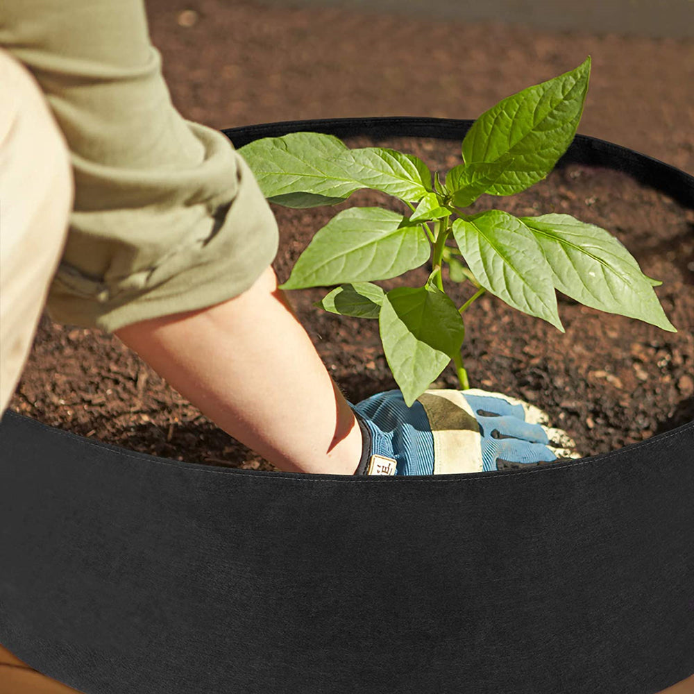 Durable Grow Bags 70cm dia 30cm high, breathable fabric; person planting a seedling in a black grow bag.