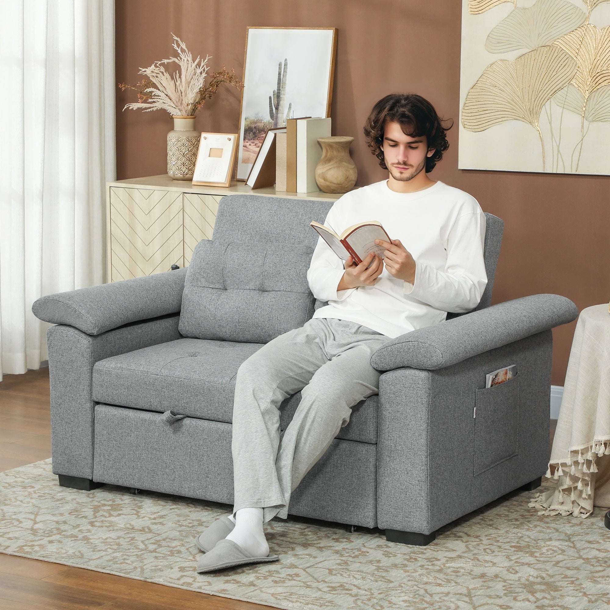 Homcom Sofa Bed Two Seater Click Clack For Living Room: man sits on dark grey fabric sofa bed in living room, reading.