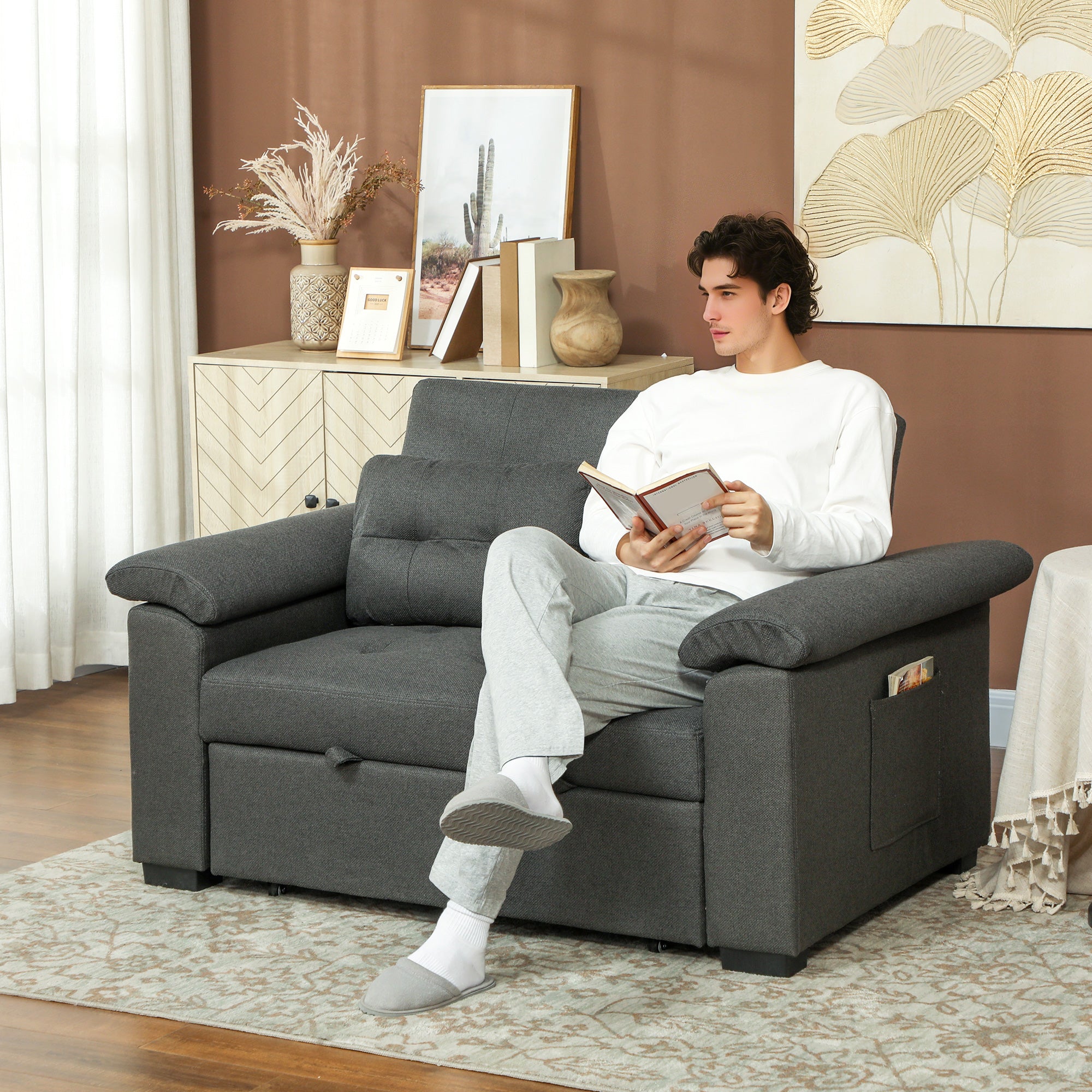 Homcom Sofa Bed Two Seater Click Clack For Living Room in dark grey fabric; man sits reading on a 3-in-1 sofa bed.