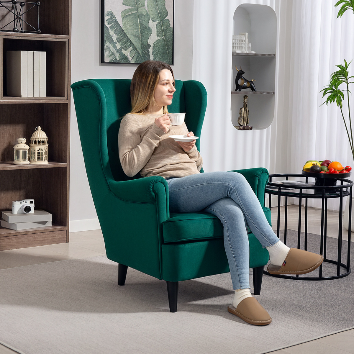 HOMCOM Wingback Chair 70cm High Velvet Comfort Living Room, a woman relaxing with tea in a green velvet chair.