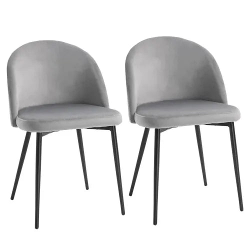 The 2 Pieces Modern Upholstered Fabric Bucket Seat Dining Chairs in grey from Unbranded feature a velvet-feel fabric, curved backs, armless design, and stand on four slender black metal legs. They exhibit a sleek minimalist look when placed side by side against a plain white background.