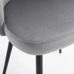 Close-up of a gray upholstered chair with sleek black metal legs, armless design, and a smooth, rounded seat. The 2 Pieces Modern Upholstered Fabric Bucket Seat Dining Chairs Living Room Grey by Unbranded features velvet-feel upholstery positioned on a white surface.